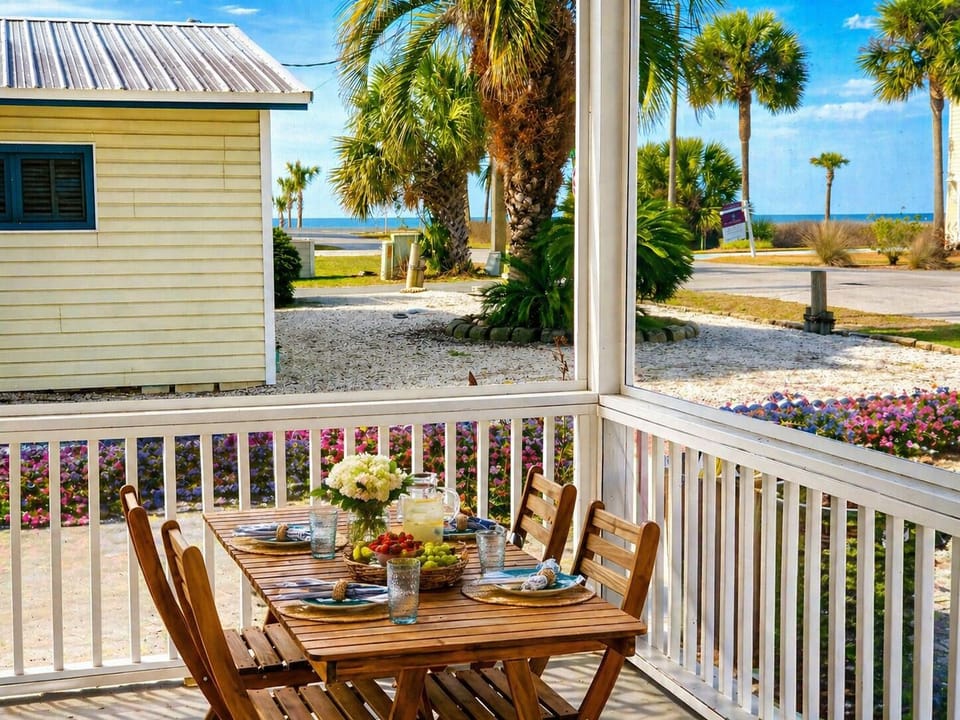 Outdoor dining on screen porch with ocean views