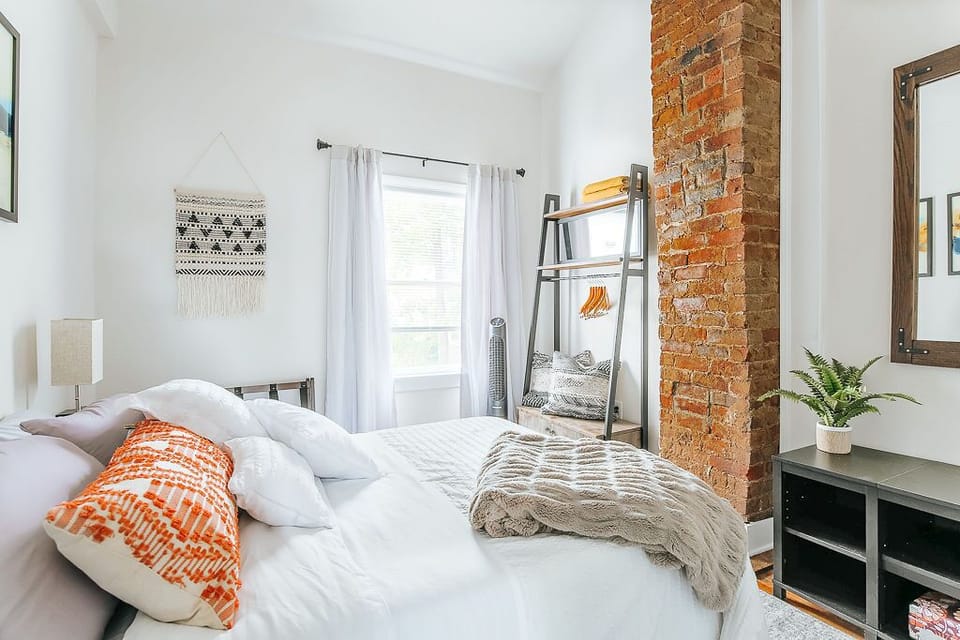 Charming bedroom with exposed brick chimney and original hardwood pine floors