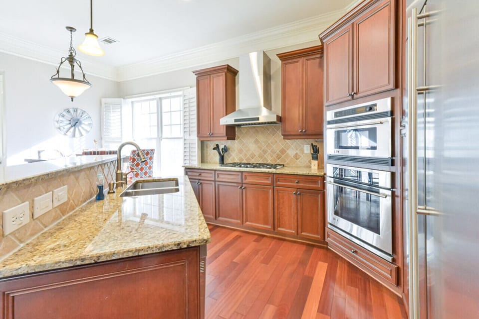 The kitchen is a modern, spacious, and well-designed area with white cabinets, a large island, and essential appliances, offering a bright and inviting atmosphere for meal preparation and enjoyment.The kitchen is a modern, spacious, and well-designed area
