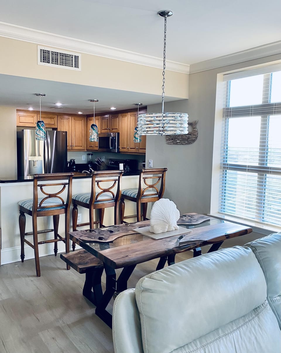 Bright dining area with rustic table and modern kitchen view