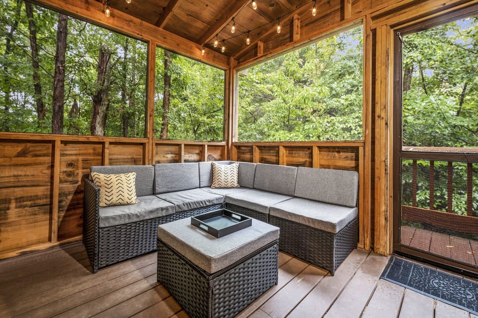 Sectional seating with hot tub, TV, and screened-in deck.