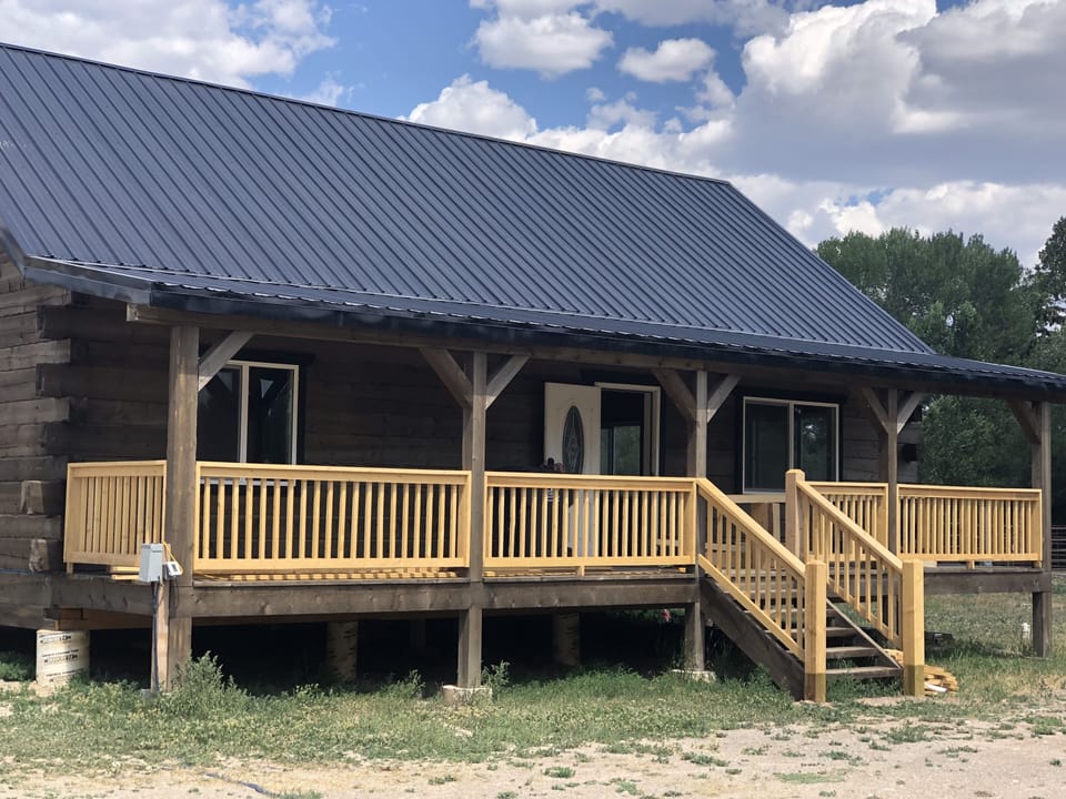Log cabin with covered front porch.