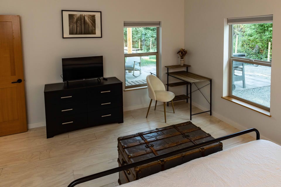 Smaller smart TV, desk space, and dresser in the master bedroom.