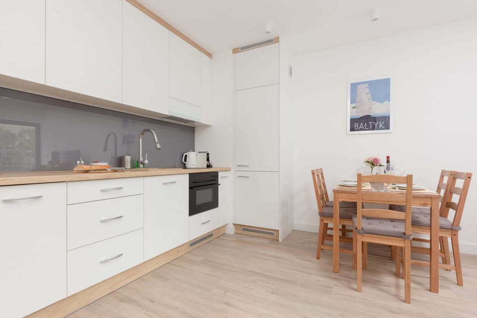 A kitchen with white cabinetry, a built-in oven, and ample counter space, blending functionality with a simple aesthetic.