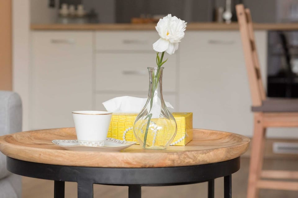 A breakfast setup on a cutting board, featuring a baguette, butter, and fresh cherry tomatoes, adding a homely and inviting touch to the kitchen area.