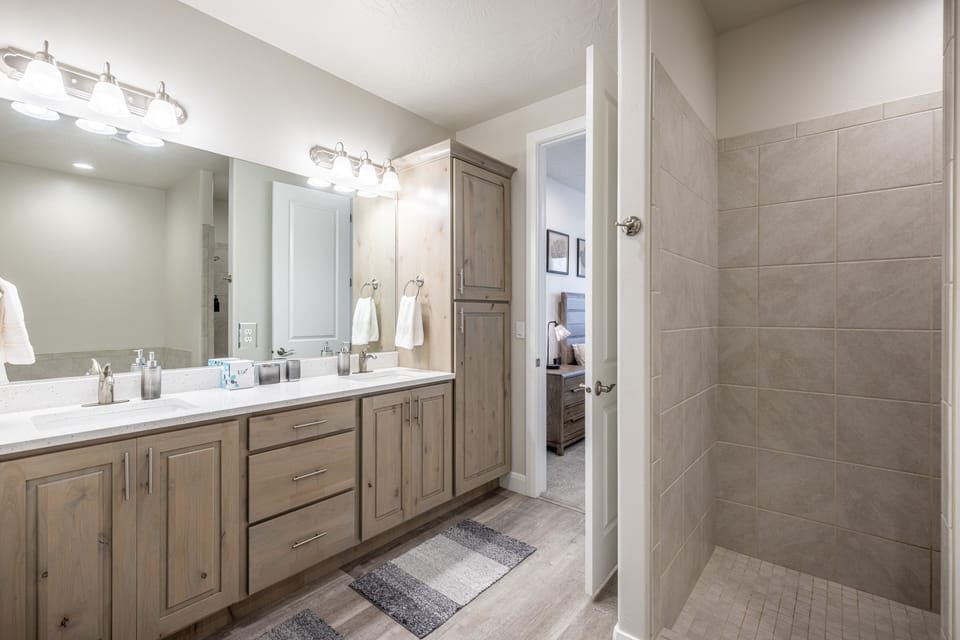 Downstairs Main Bathroom Vanity - The main bathroom that is adjacent to the main bedroom is large and luxurious. With his and her sinks, toilet, vanity, walk-in shower, large bathtub and a large walk-in closet.