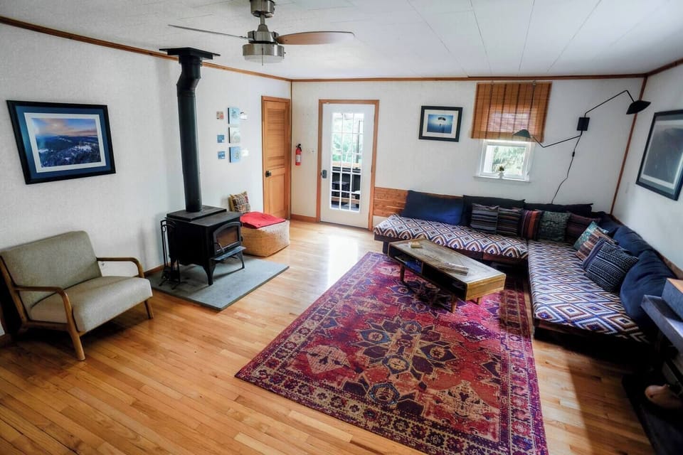 Dream House living room with wood burning fire stove and wall art of the beautiful Gunks  