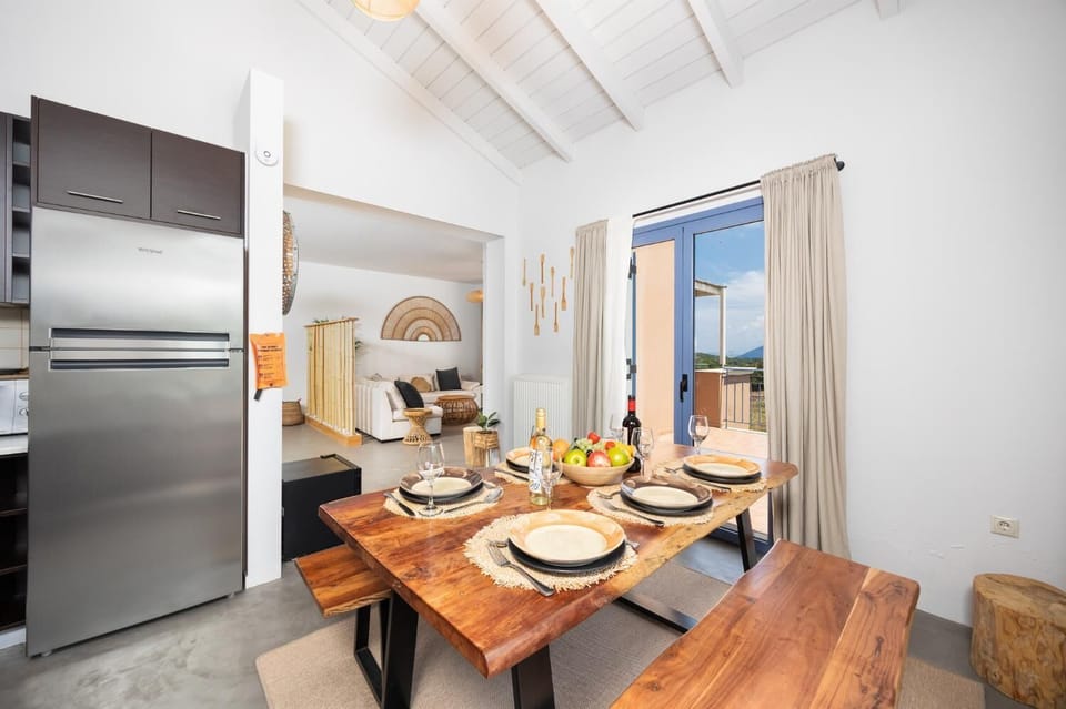 Open-plan living room with sofa, dining area, kitchen, ornamental fireplace, A/C, WiFi internet, and satellite TV