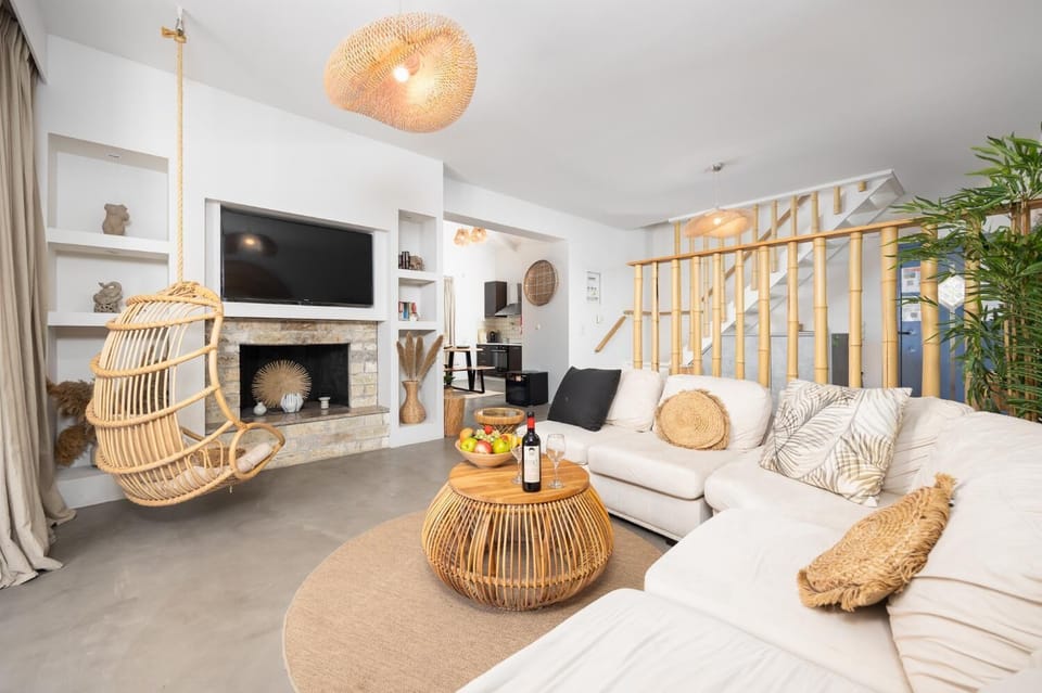 Open-plan living room with sofa, dining area, kitchen, ornamental fireplace, A/C, WiFi internet, and satellite TV