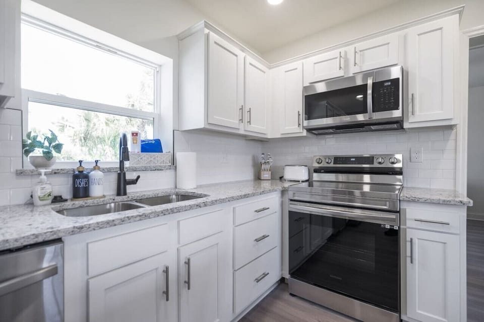 Bright open kitchen and dining space with modern appliances, cookware, and a convenient K-Cup Keurig for morning coffee.