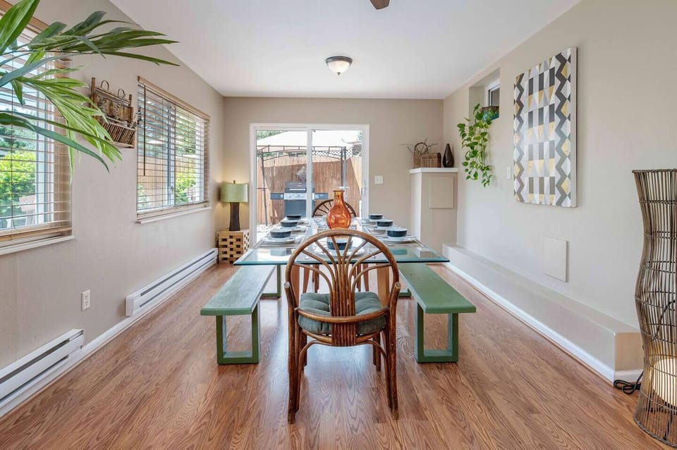 - Spacious dining area with long benches and a cozy rattan chair for hosting
- Surrounded by windows, plants, and modern wall art for a bright ambiance
- Opens to the backyard grill area, ideal for indoor-outdoor gatherings