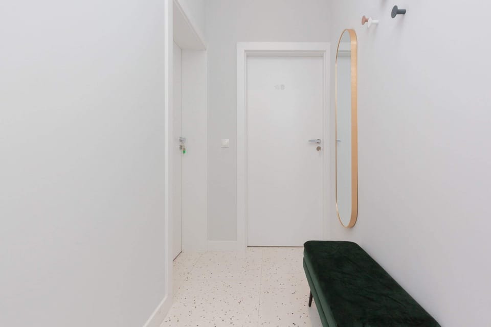 Bright hallway with white walls and spacious wardrobe.