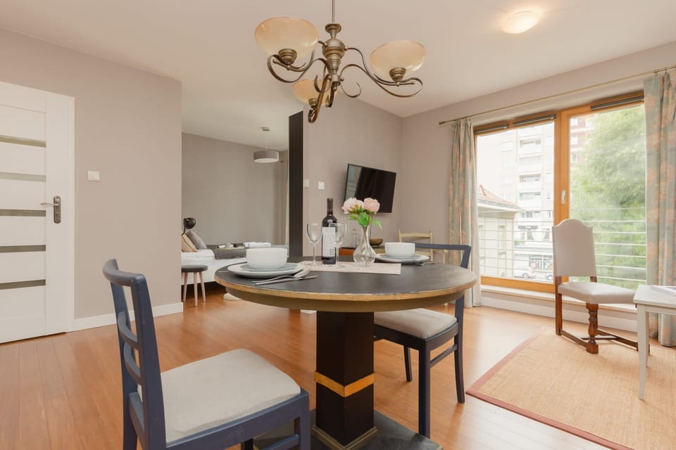 A close-up of the dining area shows the table setting, with the kitchen and windows visible in the background.