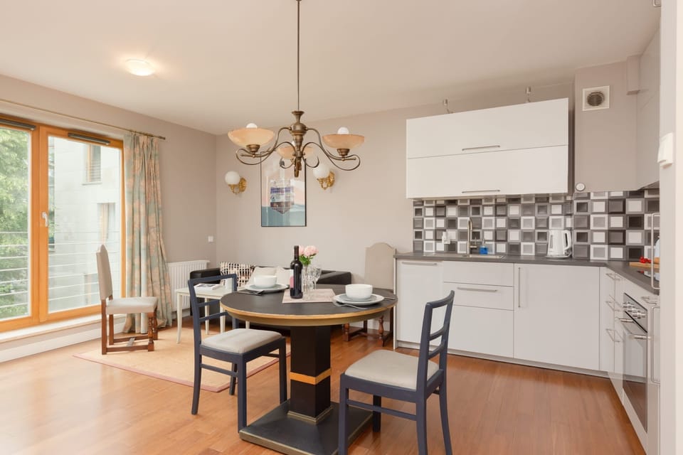 The combined living and dining area has a sofa, small dining table, and a partial view of the kitchen.