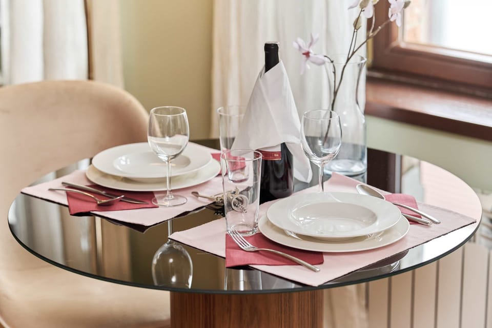 Close-up of the table set with glassware, silverware, and a small floral arrangement.