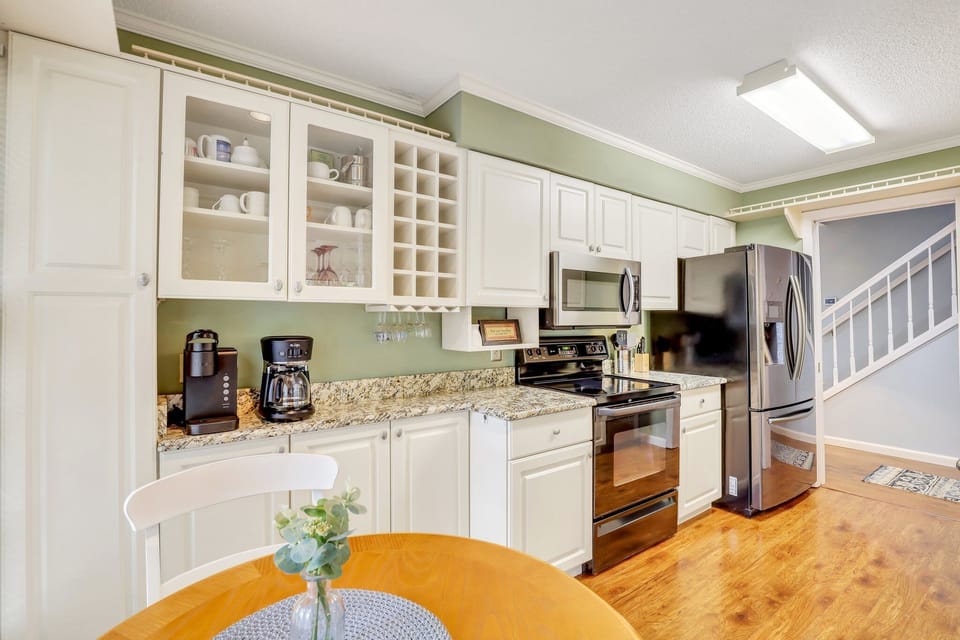 The fully stocked kitchen has stainless steel appliances and granite counter tops with a window cut out that gives the kitchen a feeling of an open floor plan while still maintaining privacy.
