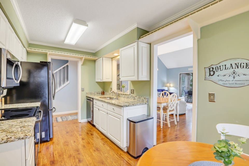 The fully stocked kitchen has stainless steel appliances and granite counter tops with a window cut out that gives the kitchen a feeling of an open floor plan while still maintaining privacy.
