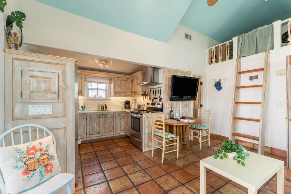 Rich terracotta floors throughout the living room and kitchen.