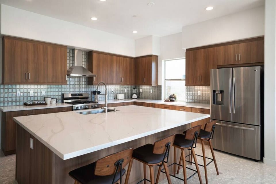 Modern kitchen w/ large island, bar seating & stainless steel appliances