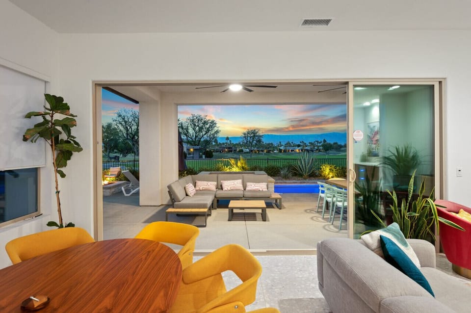 Seamless indoor-outdoor living w/ wide sliders framing the sunset