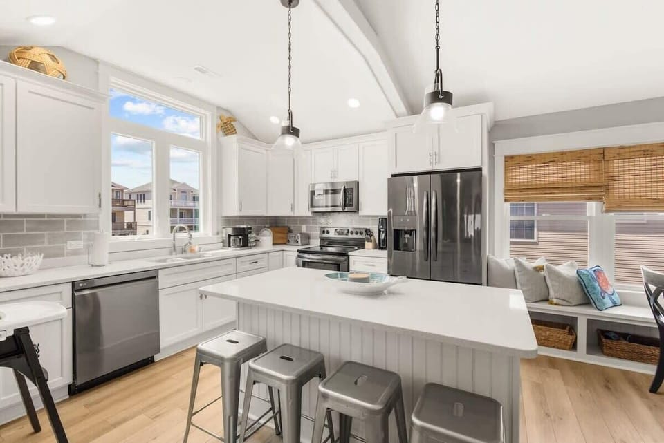 Gorgeous, updated kitchen with quartz countertops, stainless steel appliances, and a large kitchen island with seating for 4. 