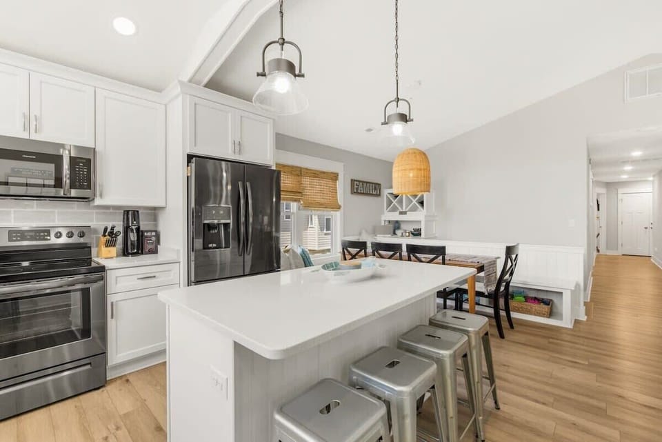 Gorgeous, updated kitchen with quartz countertops, stainless steel appliances, and a large kitchen island with seating for 4. 