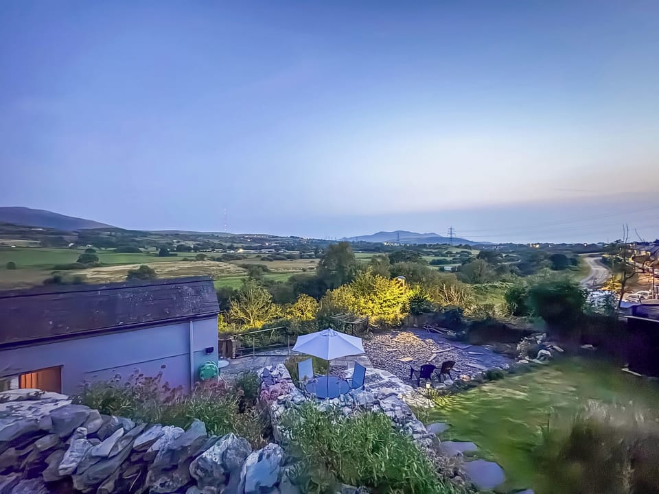 Twilight garden view out towards Llyn Penisula | Hyfrydle Cottage, Talysarn