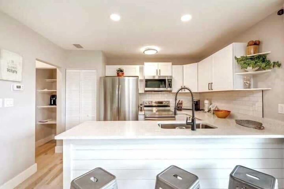 Enjoy three metal stools at the beautiful quartz breakfast bar for enjoying your meals and time together.