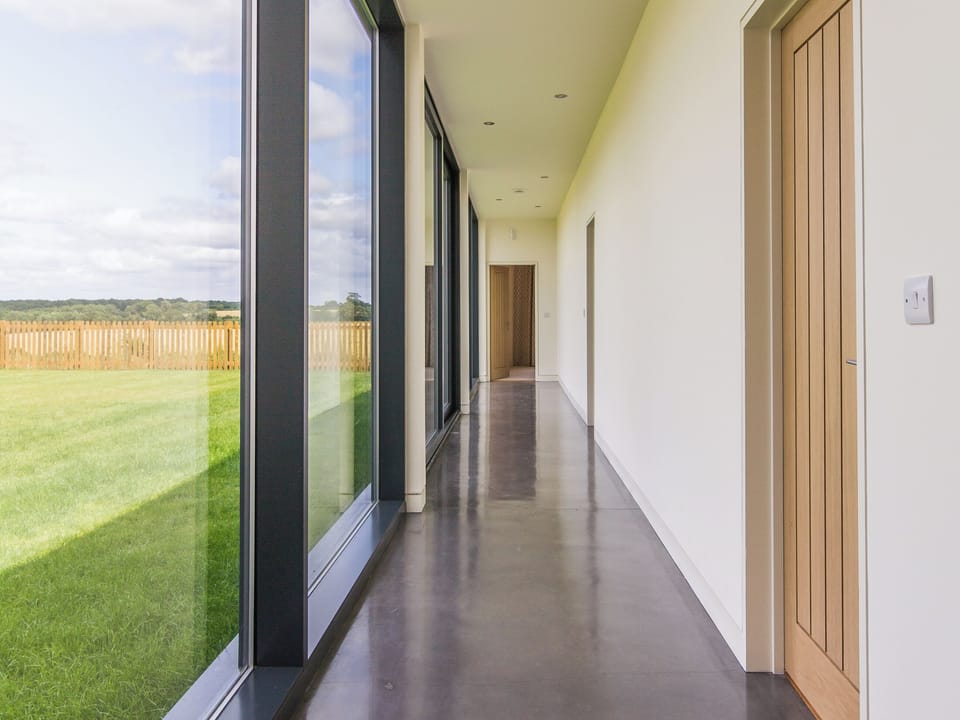Corridor with impressive glass wall | The Cotswolds Barn - Crucis, Ampney Crucis, near Cirencester