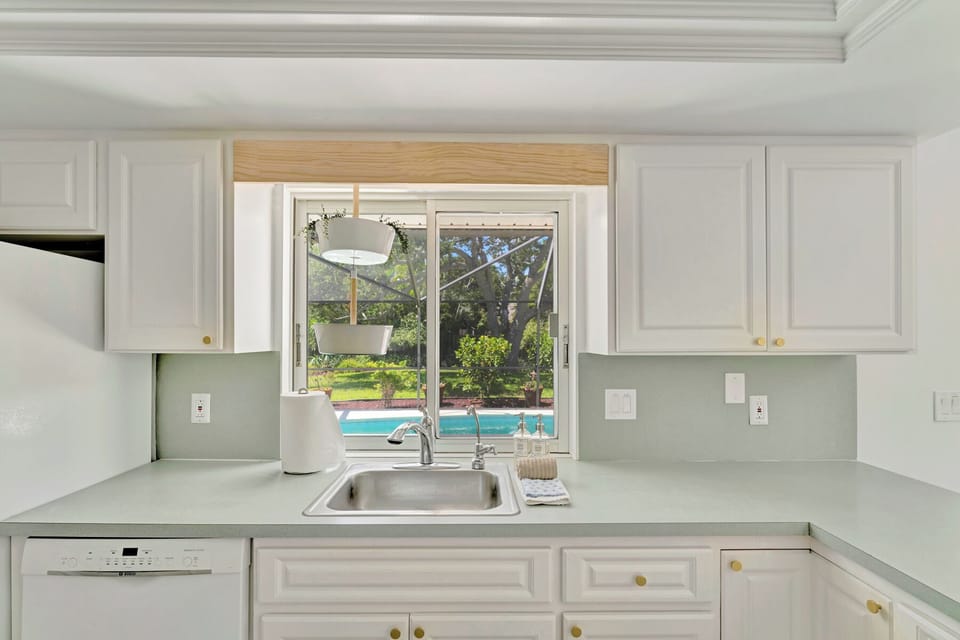 Kitchen looking out to the heated saltwater pool and backyard