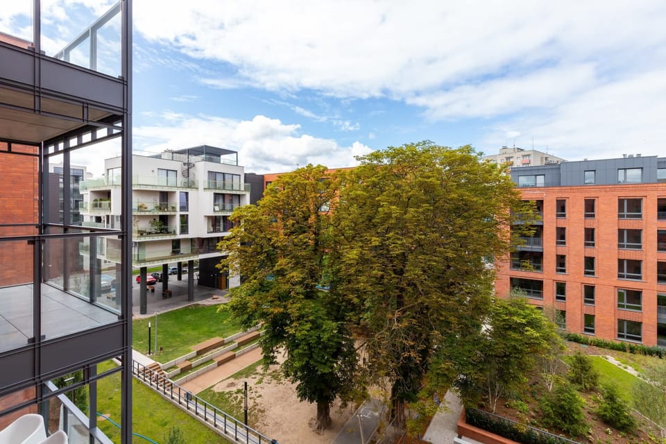 A view of the neighborhood, showcasing modern residential buildings and greenery.