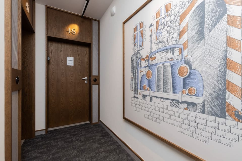 A hallway with a wooden door and vibrant wall art depicting an abstract cityscape.