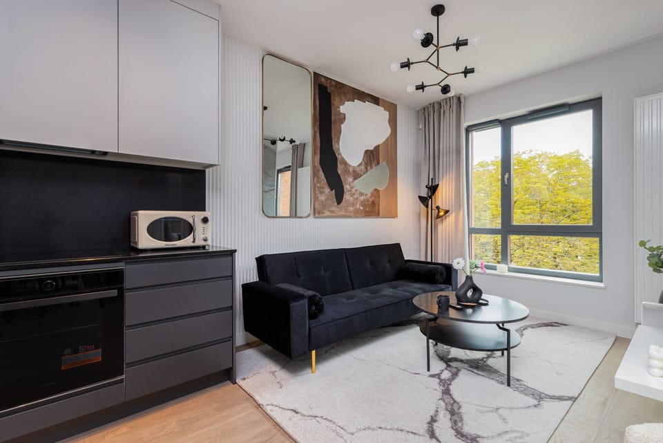 Another angle of the living space, showing a mounted TV, sofa, and coffee table.