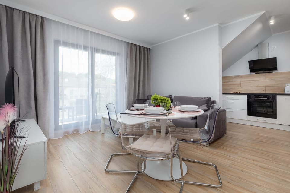 A combined dining and kitchen area with a dining table, chairs, and modern appliances.