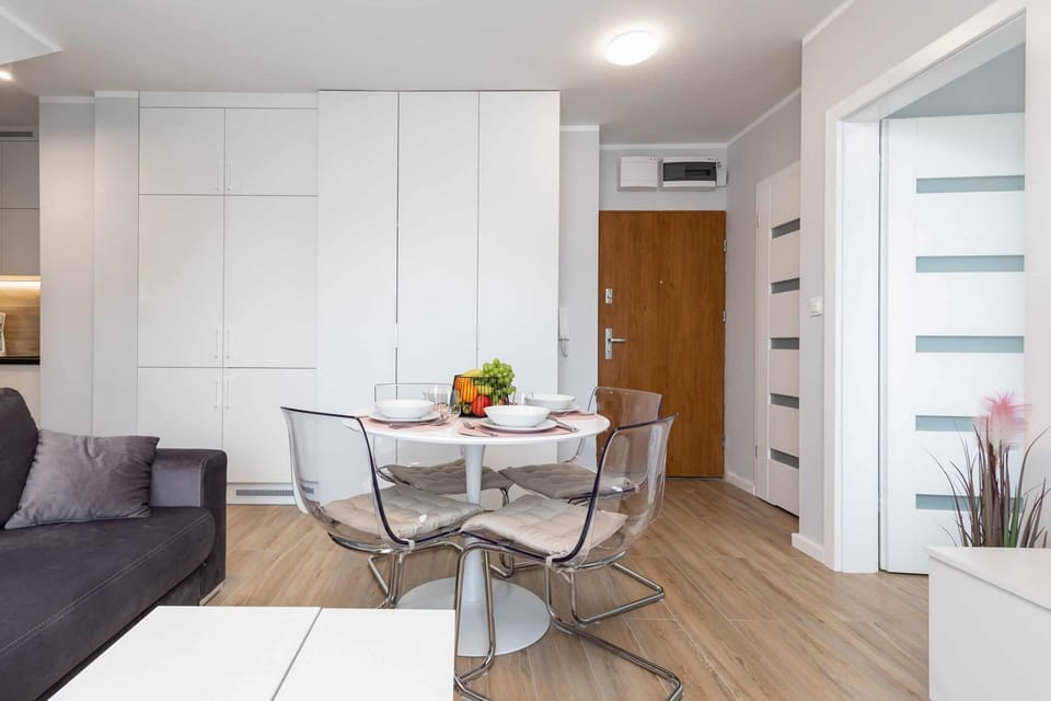 A bright living space with natural light streaming in through a large window and neatly arranged furniture.