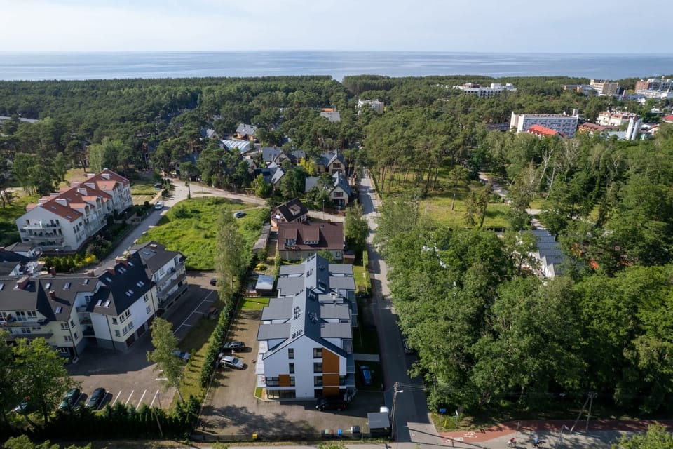 A stunning aerial view of a green neighborhood with houses and tree-lined streets.