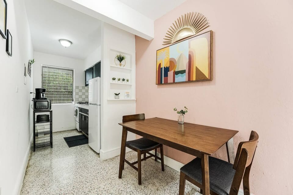  This charming dining area is perfect for enjoying meals in a relaxed atmosphere. The adjacent kitchen is equipped with essentials, including a stove, refrigerator, and microwave, making meal preparation a breeze.