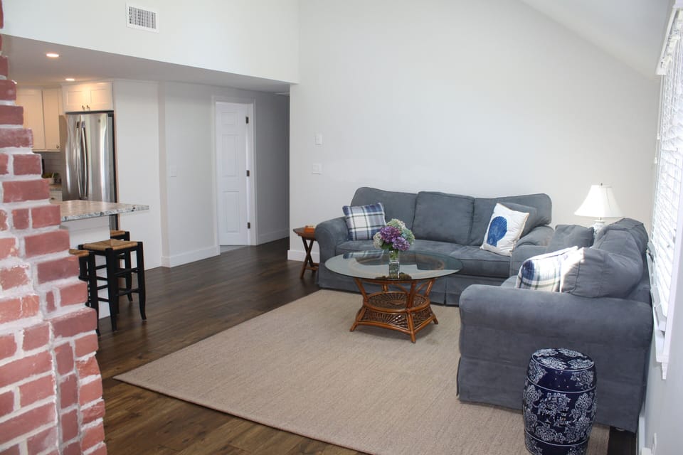 Living room and kitchen flow; the hallway leads to the 3 bedrooms and bathrooms