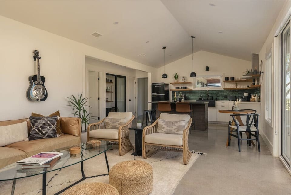 Spacious open-plan layout connecting the living room and kitchen, featuring modern finishes, cozy seating, and plenty of natural light.