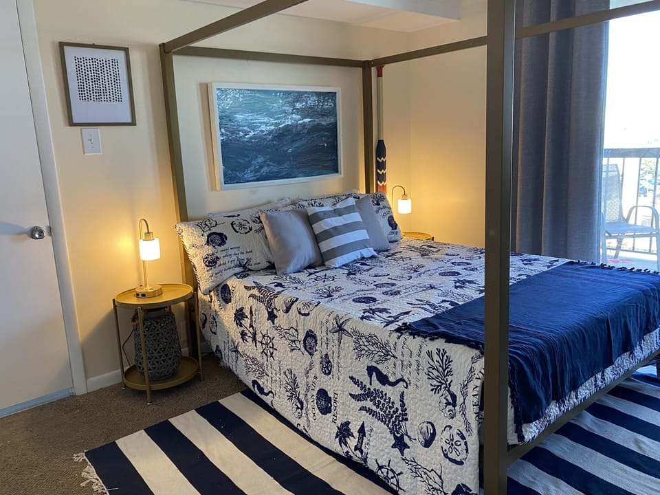 Beautiful new queen sized canopy bed with high-end bedding in primary bedroom