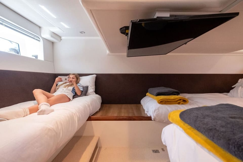 Cosy twin cabin with a mounted TV for lazy evenings below deck.