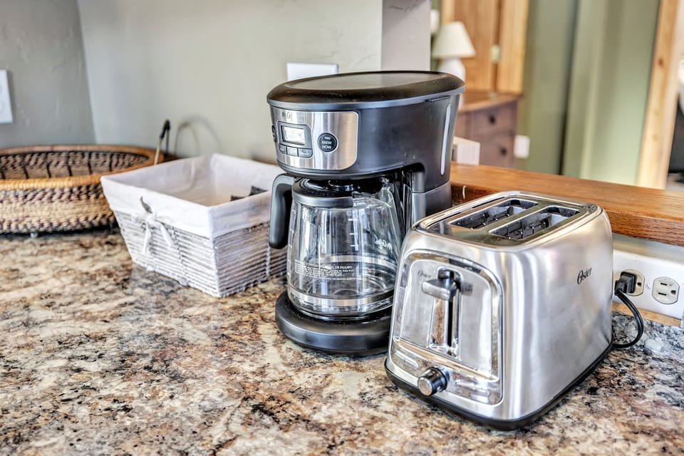 Coffee pot with coffee ground, tea bags and sugar/creamer.  Toaster. 