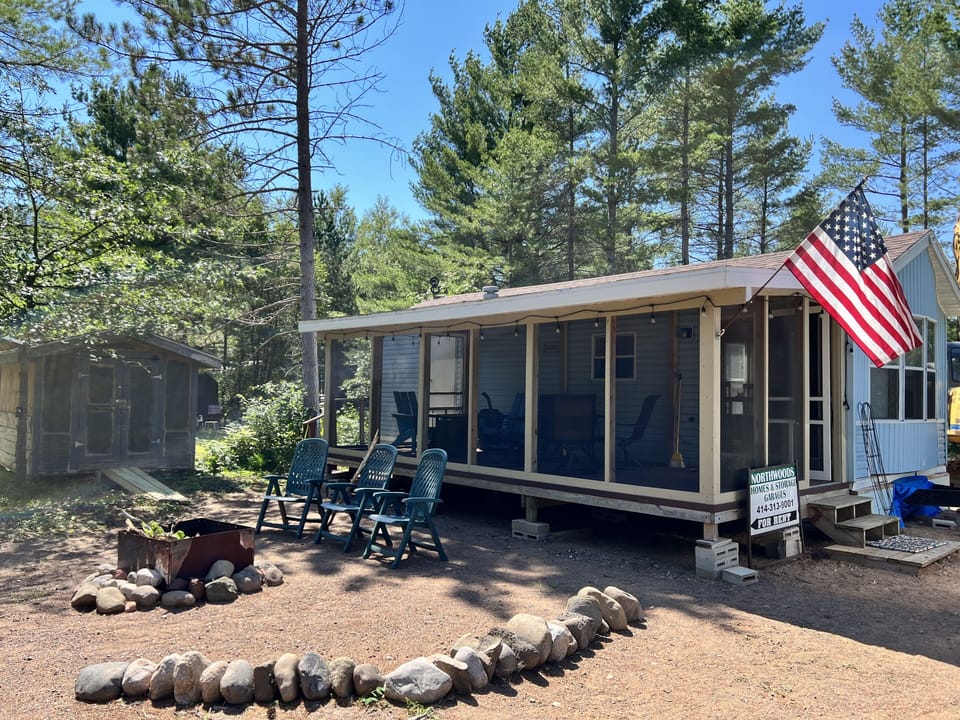 Front of Park Model w fire pit and screened in deck entrance
