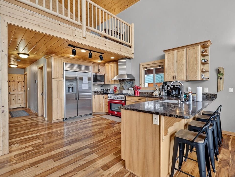 Prepare meals in this spacious kitchen featuring granite counters, stainless appliances, and a breakfast bar for casual dining together.