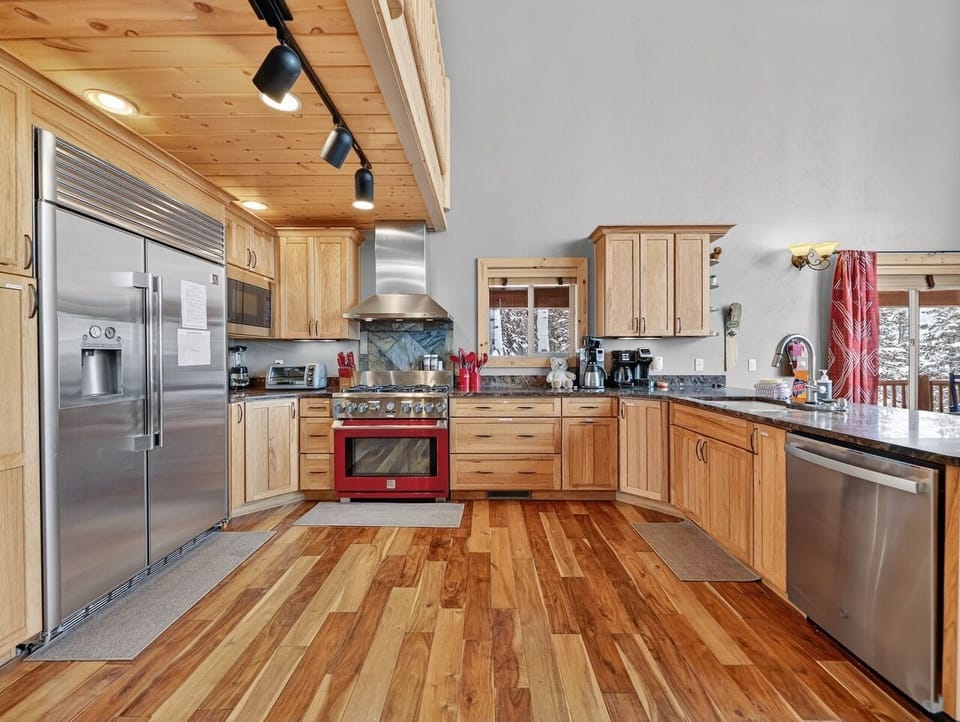 Your spacious gourmet kitchen welcomes you with warm wood tones and modern stainless steel appliances, perfect for creating memorable meals together.