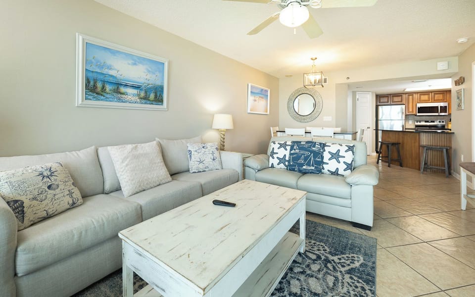 Living area features a light gray sofa with queen sleeper, striped loveseat, and stylish coffee table, for a welcoming vibe