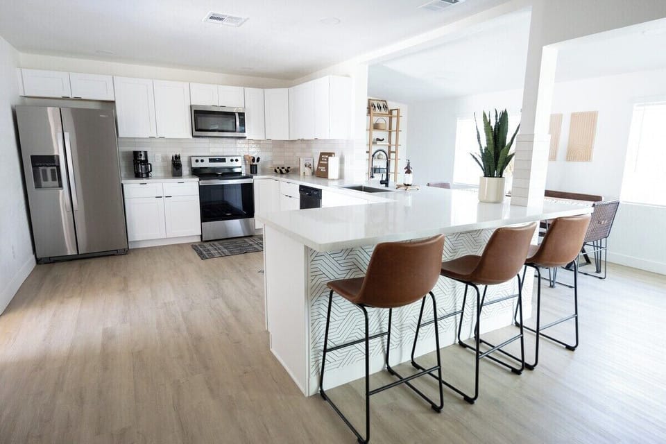 kitchen island with extra kitchen Island seating as well as a spacious kitchen, stainless steel appliances. Has all the utensils needs for plenty of meal prep and cooking. 
