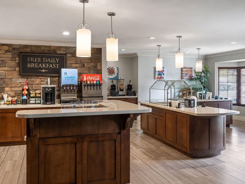 Bright breakfast station with natural light, fresh beverage options, and counter seating ready each morning