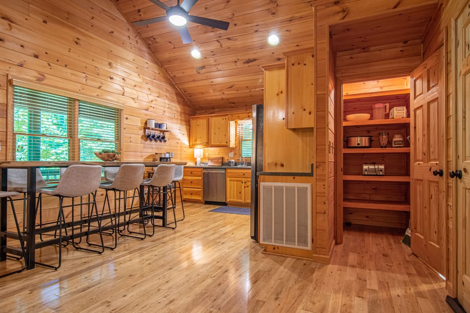 Fully stocked kitchen and seating for 8 guests at the natural wood top table.