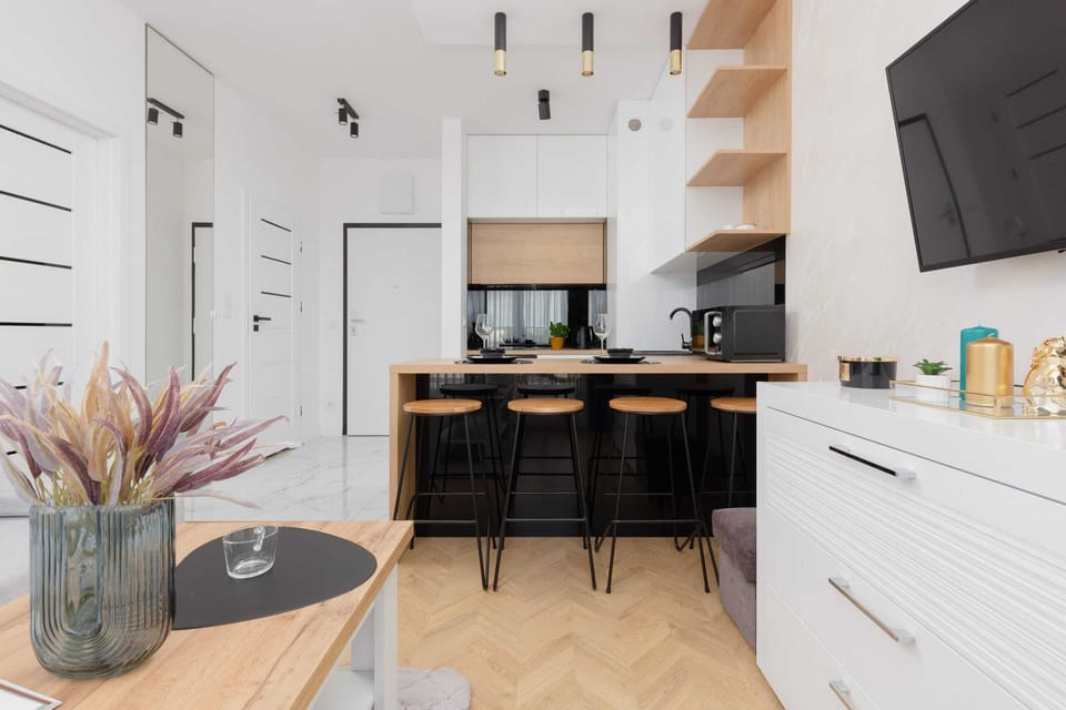 A kitchen with wooden and white cabinetry, black appliances, and an open layout.